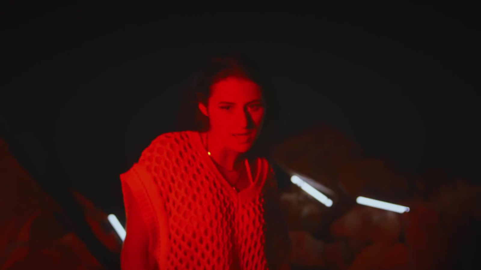 Music artist performing within a red illuminated set