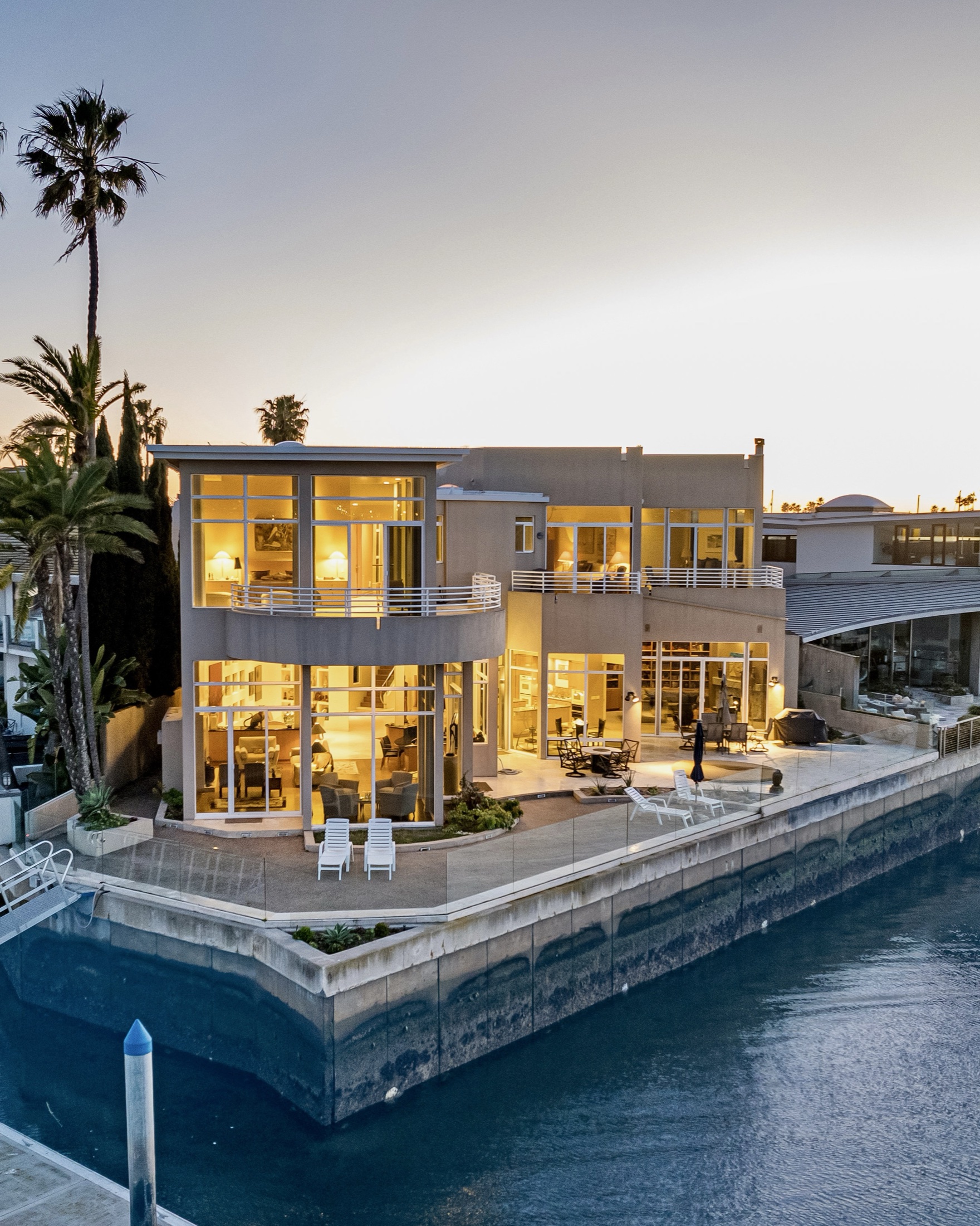 Illuminated luxury waterfront estate at twilight